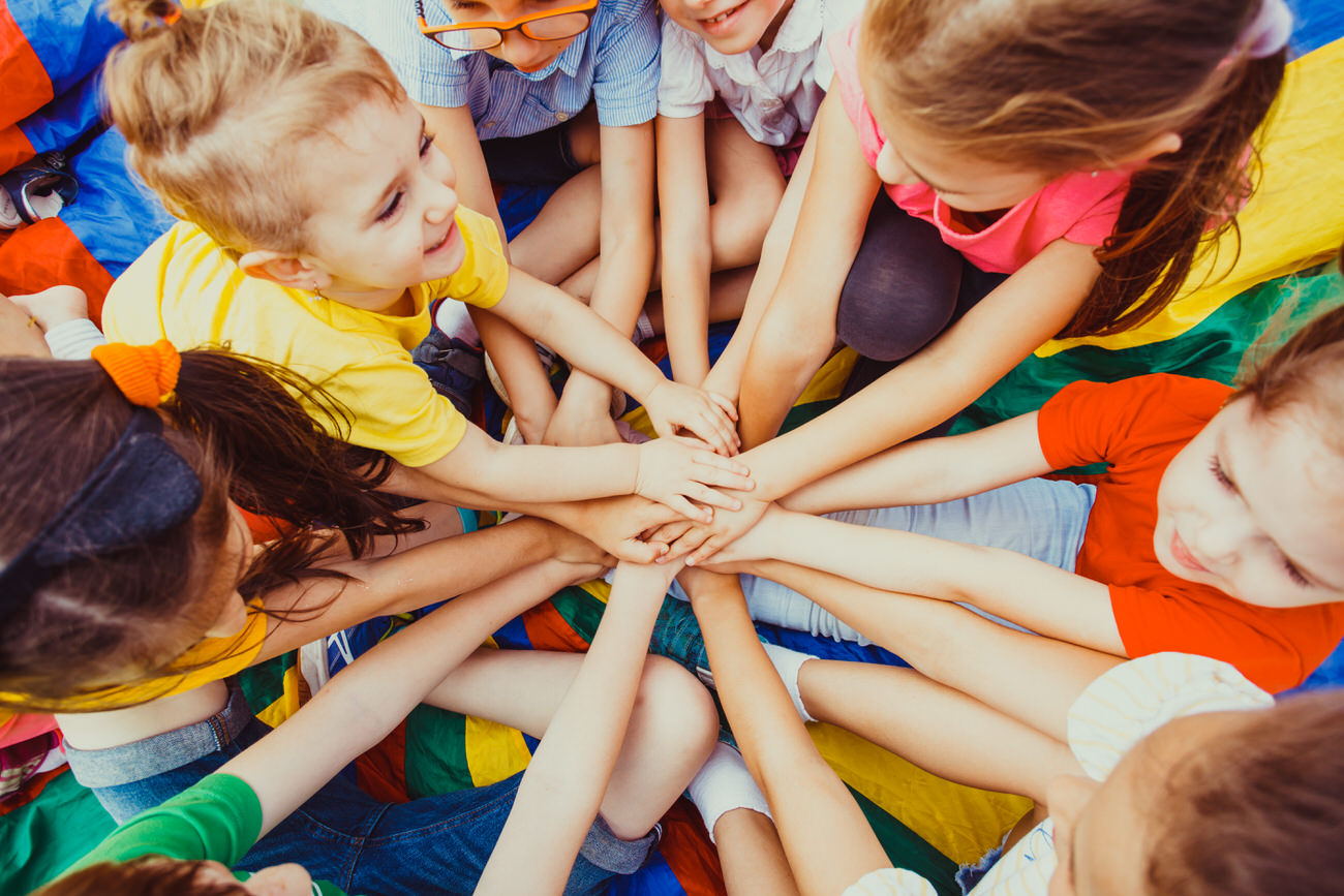 Group of children putting their hands together