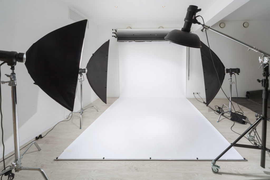 Photographic equipment and a white backdrop in studio.